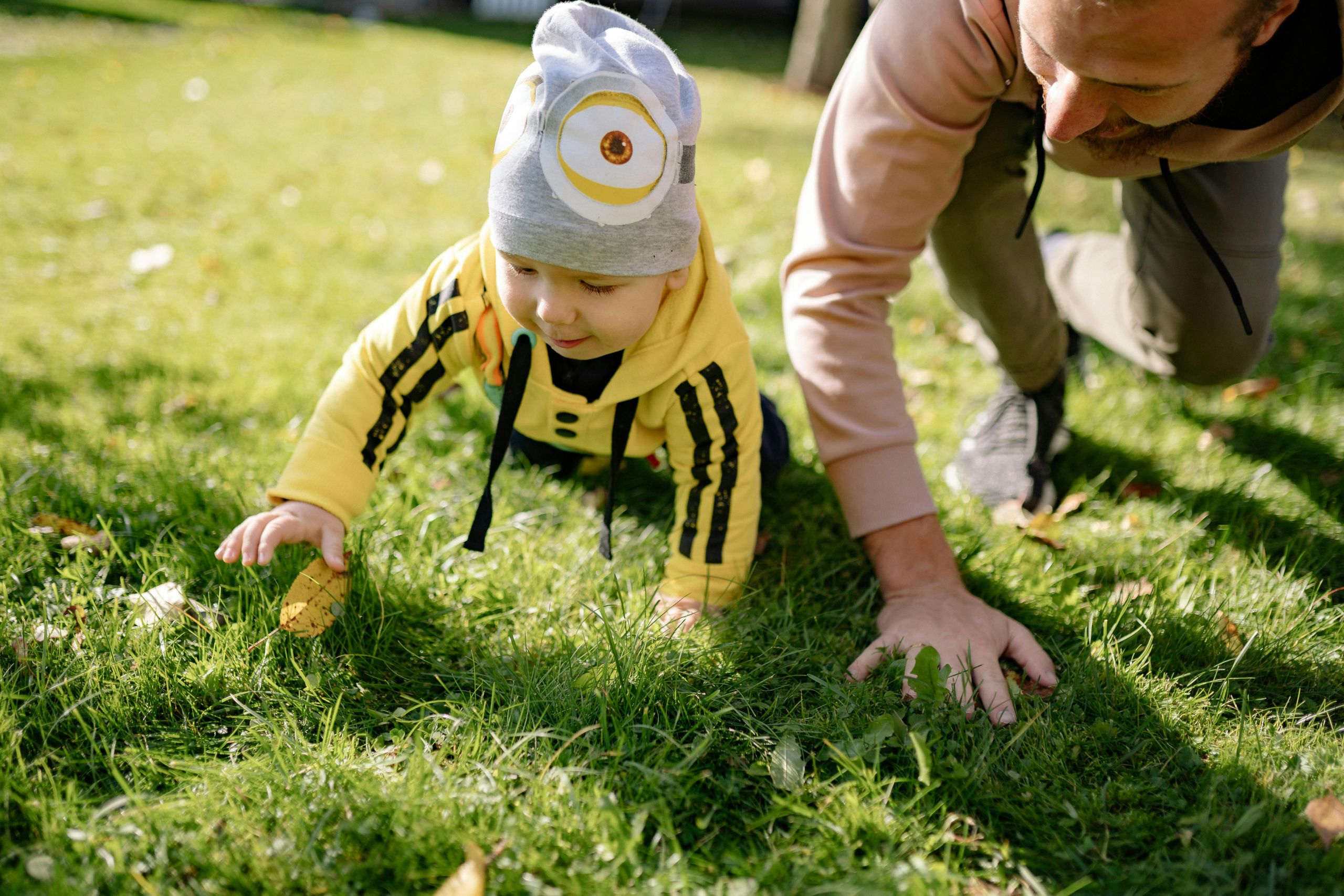 Man and child crawling A man and a child crawling in the grass